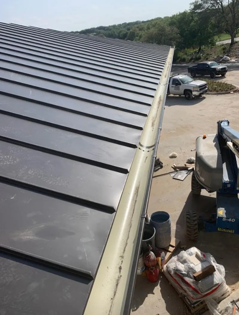 Standing seam panel and gutter detail on a metal roofing jobsite in Prairie Ridge
